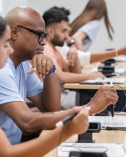 Students seated at laptops in a classroom during a cybersecurity training session
