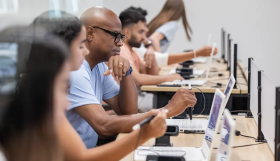 Students seated at laptops in a classroom during a cybersecurity training session